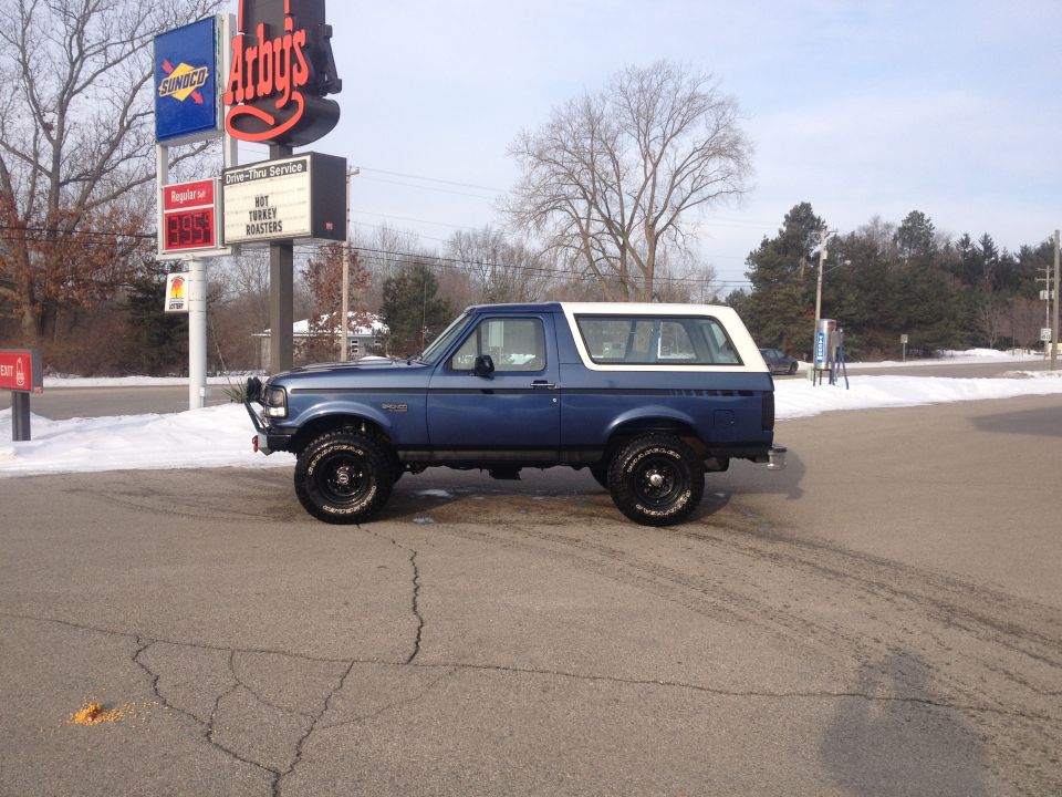 Blue Ford Bronco with white removable top parked near Arby's