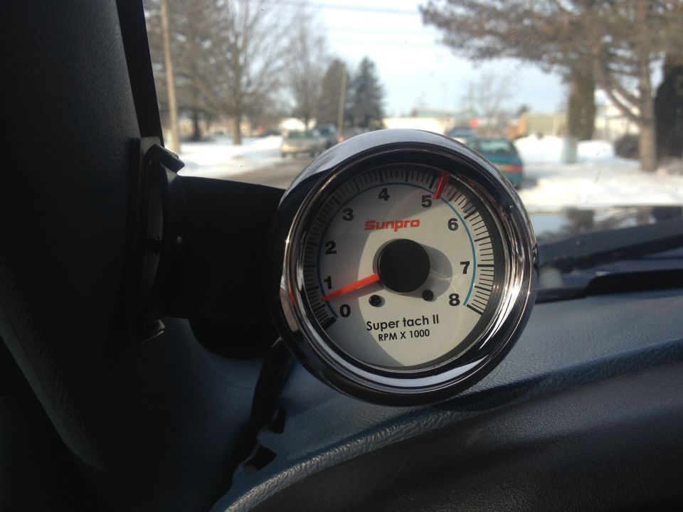 Sunpro Super tach II RPM gauge mounted on dashboard