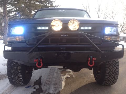 1996 Ford Bronco - Frontal view of a modified Ford truck with custom bumper and auxiliary lighting.