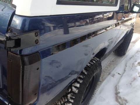 1996 Ford Bronco - This SUV, likely a Ford Bronco, is seen from the side in a snowy environment. The vehicle has a two-tone paint scheme.