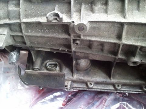 1994 Ford Bronco - This is a close-up view of a vehicle's transmission housing, showing its metallic texture and a connector.