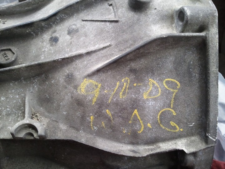Gray metal transmission housing with yellow markings '9/10-D9' and 'J.A.G.'