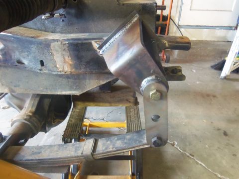 1968 Ford Bronco - Close-up of a custom-welded bracket modifying the suspension system, likely for a gas tank modification.