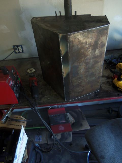 1968 Ford Bronco - A custom-fabricated metal fuel tank sits on a workbench, showing signs of rust and welding.