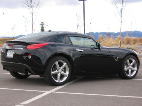 1995 Ford Bronco - This black Pontiac Solstice GXP Coupe is shown from the rear three-quarter angle in a parking lot.