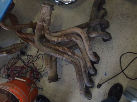 1978 Ford Bronco - Exhaust manifolds and wiring are shown on a concrete floor, possibly in a garage or workshop.