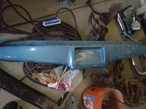 1978 Ford Bronco - A blue dashboard trim piece is shown with various automotive parts and electrical wiring scattered around it.
