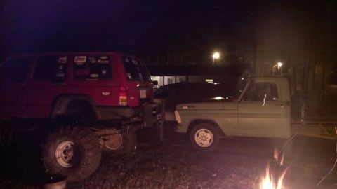 1978 Ford Bronco - Two modified SUVs are parked side-by-side at night, with one appearing to be a Ford pickup truck.