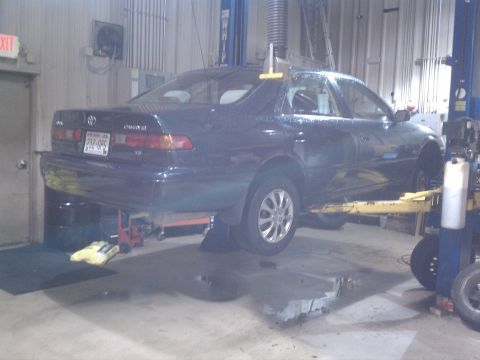 1998 Toyota Camry - 1998 Toyota Camry undergoing repairs on a lift in a workshop.