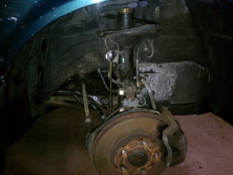 1998 Toyota Camry - This photo shows the front suspension and brake components of a vehicle, likely during a repair or inspection.