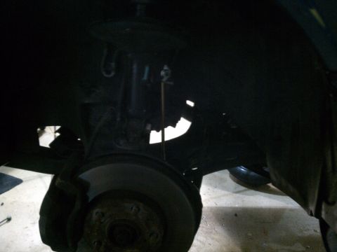 1998 Toyota Camry - Front suspension and brake assembly of a car, viewed from the wheel well.