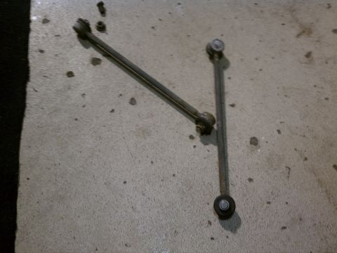 1998 Toyota Camry - These are two car suspension stabilizer links, possibly for a Toyota Camry, resting on a concrete surface.