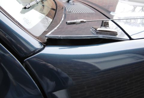 1996 Ford Bronco - The shot focuses on the hood and windshield area of a dark-colored vehicle, showing an antenna mount.