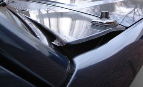 1996 Ford Bronco - Close-up view of a car's hood and antenna mount, showing reflections.