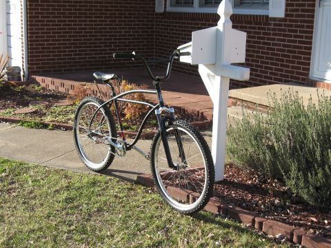 1994 Ford Bronco - A cruiser bicycle is parked on a sidewalk next to a mailbox in front of a brick house.