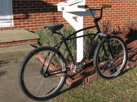 1994 Ford Bronco - A custom black bicycle with wide handlebars and knobby tires is positioned outdoors next to a white mailbox.