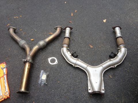 1996 Ford Bronco - Two exhaust Y-pipes and gaskets are laid out on an asphalt surface.