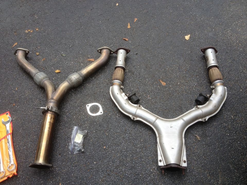 Two exhaust Y-pipes and gaskets on asphalt