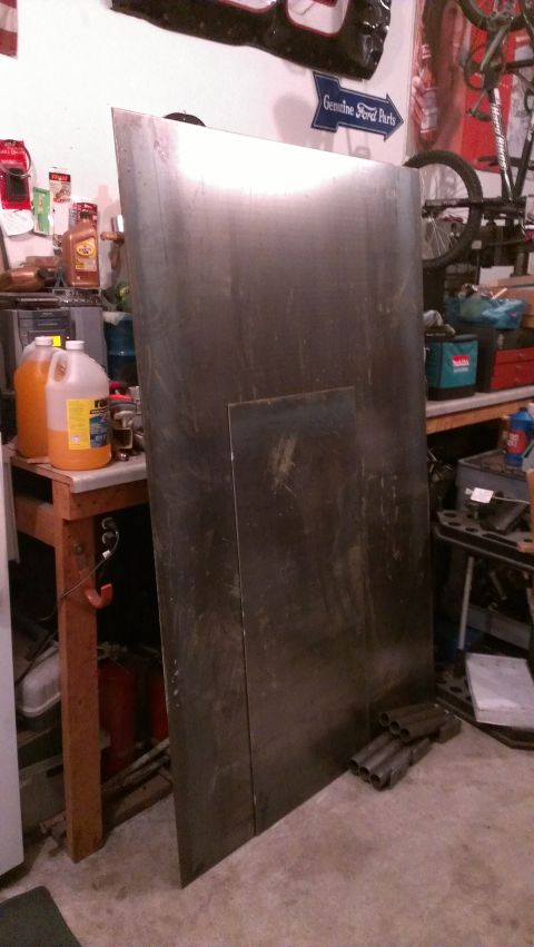 1995 Ford Bronco - A large sheet metal panel is the main subject in this workshop scene, with no vehicle visible.