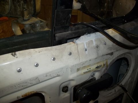 1990 Ford Bronco - Close-up view of the inside of a vehicle door, showing exposed metal and mounting hardware.
