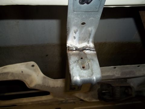 1990 Ford Bronco - Close-up of a welded metal bracket on the underside of a vehicle, showing repair work.