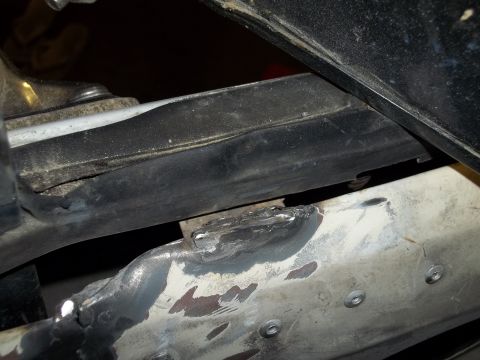 1990 Ford Bronco - This photo shows a close-up view of metalwork and trim on a vehicle's undercarriage.