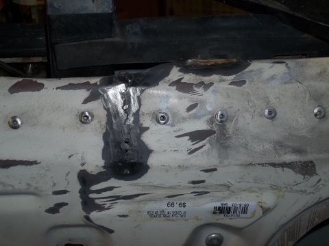 1990 Ford Bronco - Close-up of a repaired metal panel with visible welding and bolt heads, suggesting auto body work.