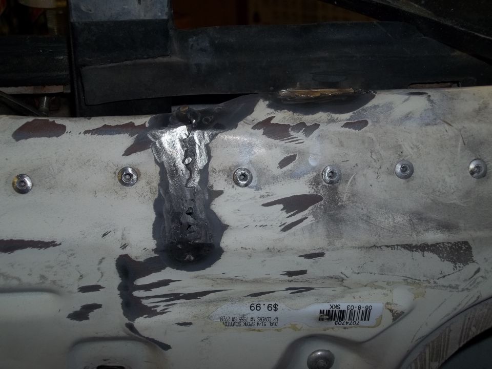 White metal panel with visible welds and bolt heads