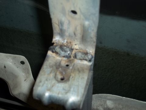 1990 Ford Bronco - Close-up of a welded metal bracket, showing signs of wear and repair. The Supermotors.net logo is visible in the lower right corner.