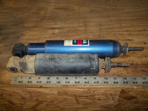 1990 Ford Bronco - Two shock absorbers, one blue and one black, are shown with a ruler for size comparison.