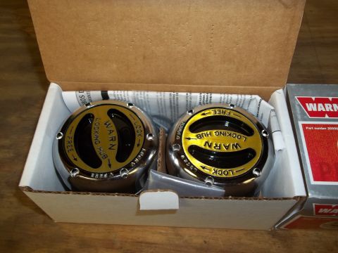 1990 Ford Bronco - Two Warn locking hubs are shown in their packaging, ready for installation on a vehicle.