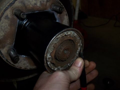 1990 Ford Bronco - Close-up of a rusty wheel hub assembly being worked on.