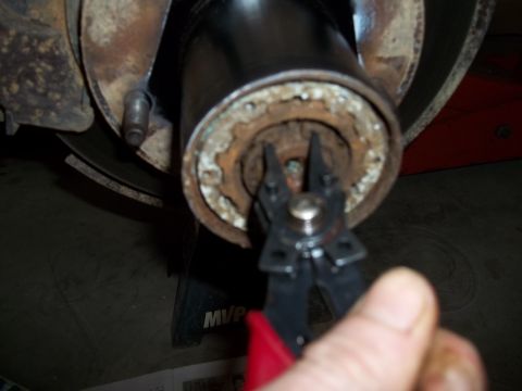 1990 Ford Bronco - Using snap ring pliers on a vehicle's brake drum and hub assembly.