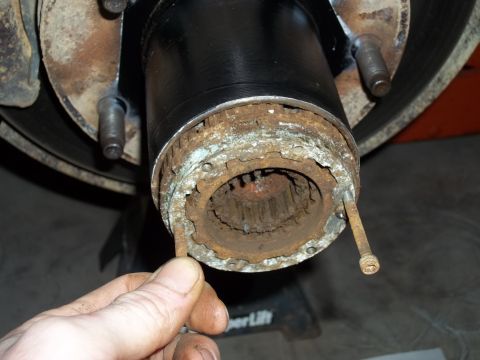 1990 Ford Bronco - Close-up of a heavily corroded wheel hub assembly, indicating a need for repair or replacement.