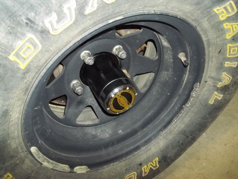 1990 Ford Bronco - A close-up view of a vehicle's wheel, a black hubcap and tire with yellow lettering.