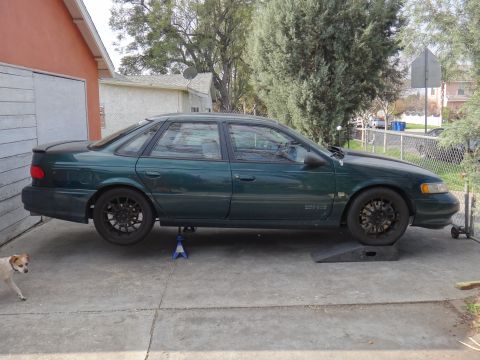 1995 Ford Taurus - Green 1995 Ford Taurus sedan is raised on jack stands for maintenance.