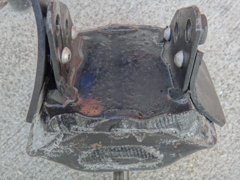 1995 Ford Taurus - This is a close-up view of a metal exhaust hanger bracket, showing its construction and mounting points.