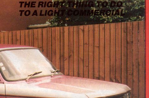 1969 Lincoln Continental - Pink car hood and windshield visible in front of a wooden fence.