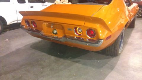 1973 Chevrolet Camaro - The rear of an orange 1973 Chevrolet Camaro is shown, its distinctive taillights and spoiler.