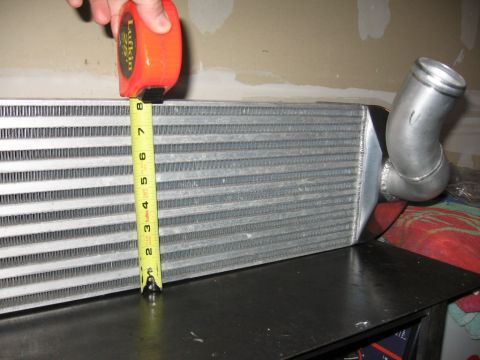 1995 Ford Bronco - A tape measure is used to measure the dimensions of an intercooler, a component of a vehicle's air intake system.