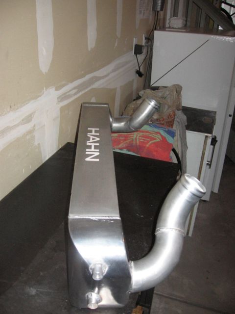 1995 Ford Bronco - A Hahn branded intercooler sits on a dark surface in front of a wall and some storage units.