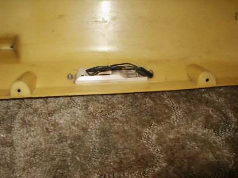 1966 Ford Bronco - A close-up view of a yellow plastic panel with an interior light fixture and wiring.