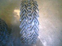 1992 Ford Bronco - A close-up view of a tire's tread shows an aggressive, geometric pattern designed for off-road traction.