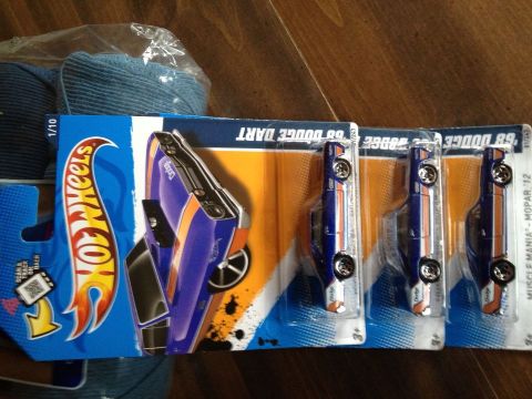 1988 Ford Bronco - Several Hot Wheels toy cars are displayed in their original packaging on a wooden surface.