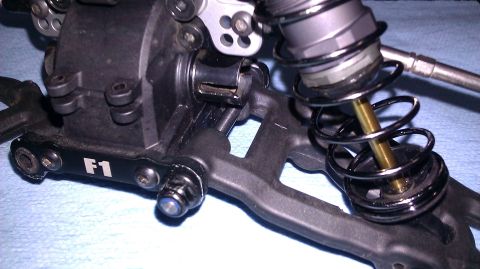 1996 Ford Bronco - Close-up of an RC car's suspension component, a shock absorber and a visible "F1" marking.