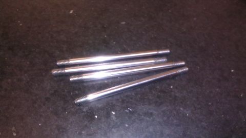 1996 Ford Bronco - Five threaded metal rods are shown on a dark, speckled surface.