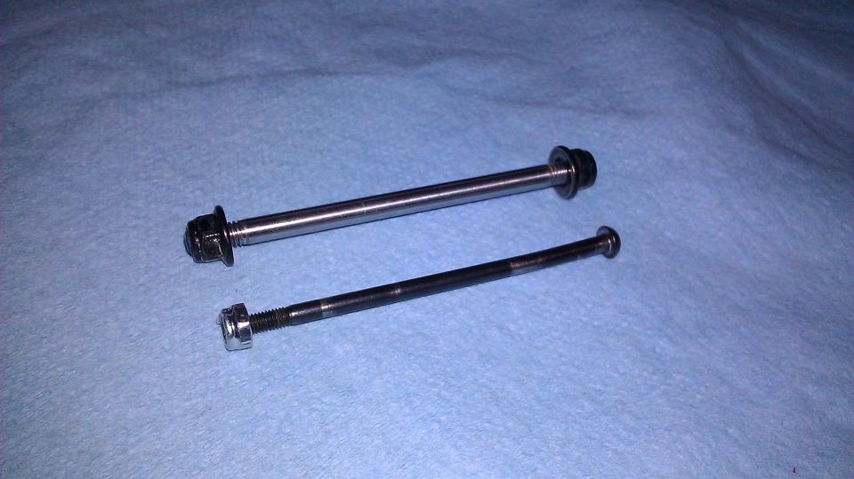 two bolts, one silver and one black, on a blue cloth surface