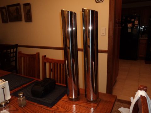 2004 Mercury Grand Marquis - Pair of chrome exhaust tips displayed indoors on a wooden table.