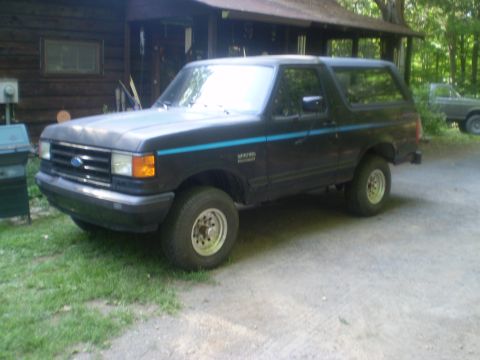 1979 Ford Bronco - Ford Bronco parked outside a cabin with another vehicle in the background.