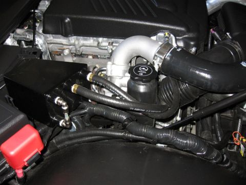 1995 Ford Bronco - Close-up view of engine components, including turbocharger piping and a black reservoir tank.